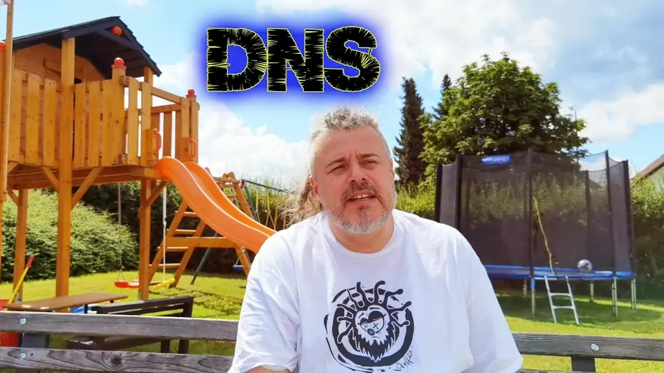 Still from “DNS”: Marko in a garden in front of a children’s play tower